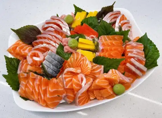 Món Ngon Với Cá Hồi Khám Phá Những Món Ăn Ngon Miệng Và Dinh Dưỡng 4 Bức ảnh là một đĩa sashimi cá hồi tươi, được cắt lát mỏng, đẹp mắt. Lát cá hồi có màu hồng tươi, mềm mại và bóng bẩy, ăn kèm với gừng tươi và một chút wasabi, tạo nên một món ăn nhẹ nhàng nhưng đầy lôi cuốn, mang đậm hương vị Nhật Bản.