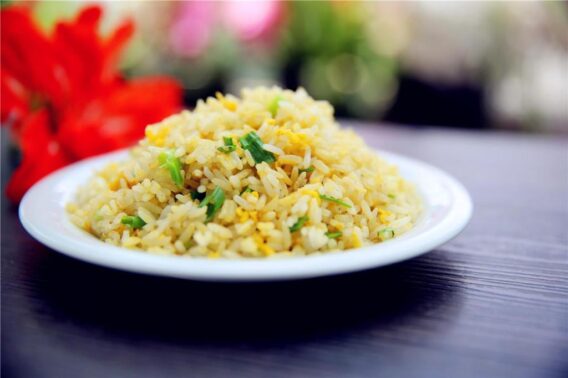 Món Ngon Với Trứng 10 Công Thức Đơn Giản Và Hấp Dẫn Cho Mọi Bữa Ăn 3 Hình ảnh của một đĩa trứng chiên cơm nóng hổi, với các hạt cơm vàng ươm, hòa quyện cùng trứng và các loại rau củ tươi ngon như cà rốt, đậu que.