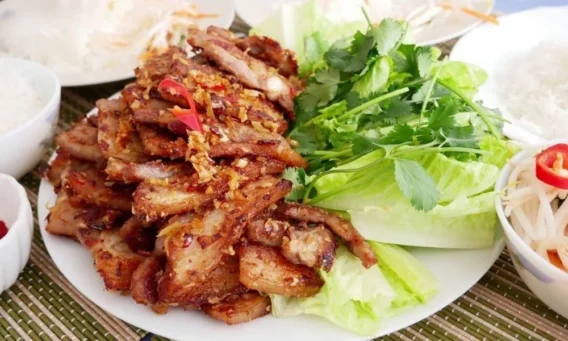 Món Ngon Với Thịt Ba Chỉ 10 Công Thức Đầy Hấp Dẫn Dành Cho Bữa Cơm Gia Đình 4 Một đĩa thịt ba chỉ nướng sả vàng ươm, lớp ngoài giòn thơm, thịt bên trong mềm và ngọt tự nhiên, được trình bày đẹp mắt với rau sống và dưa leo. Món ăn này không chỉ bắt mắt mà còn thơm lừng, khiến bạn không thể chối từ ngay từ lần đầu thưởng thức.