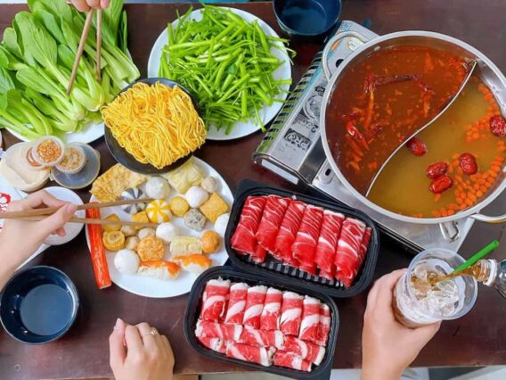 Khám Phá Những Món Ngon Quận 2 Thiên Đường Ẩm Thực Sài Gòn 4 Hình ảnh một nồi lẩu Thái nóng hổi với nước dùng đỏ au, đầy đủ tôm, cá, nấm và rau củ tươi ngon.